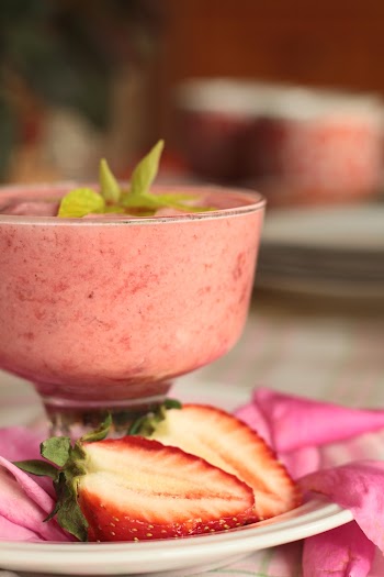 Sliced Strawberries on White Plate Beside a Glass filled with Strawberry Shake