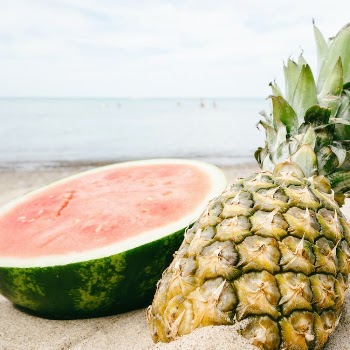 Sliced Watermelon and Pineapple Near Seashore