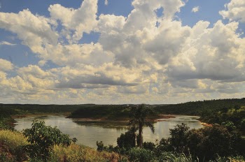 Small Body of Calm Water Under Cloudy Blue Sky at Daytime