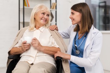 Smiley old woman talking to caregiver Free Photo