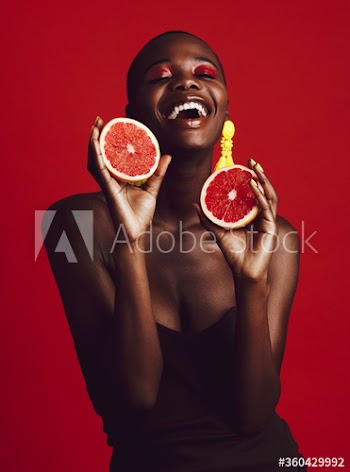 Smiling african female model holding grapefruit