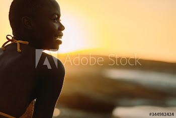 Smiling african woman on the beach at sunset