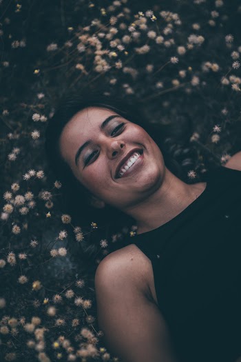 Smiling and Lying Woman in Black Crew-neck Sleeveless Top
