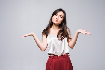 Smiling asian woman showing copy space for product isolated on white wall. Free Photo