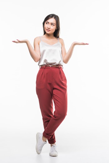 Smiling asian woman with open palms showing copy space for product isolated on white wall. Free Photo