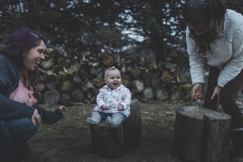 Smiling Baby Sitting on Cut Tree Log