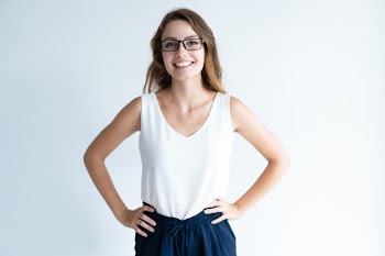 Smiling beautiful lady standing and keeping hands on hips