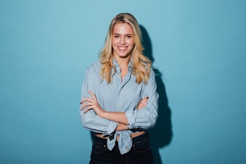Smiling blonde woman in shirt posing with crossed arms Free Photo