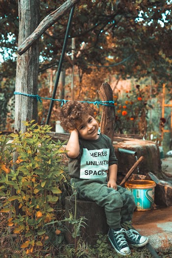 Smiling Boy Sitting on Brown Stool