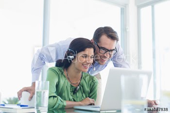 Smiling business people using laptop