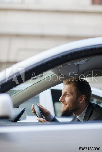 Smiling businessman driving car