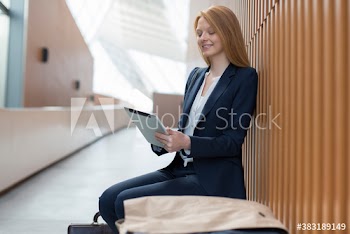 Smiling businesswoman using digital tablet in modern office