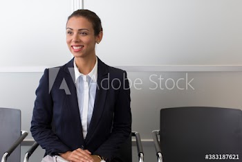 Smiling businesswoman waiting in office lobby