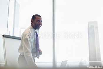 Smiling corporate businessman preparing for conference room meeting