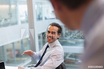 Smiling corporate businessmen talking in office