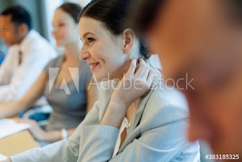 Smiling corporate businesswoman listening in music