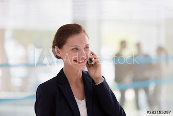 Smiling corporate businesswoman talking on smart phone