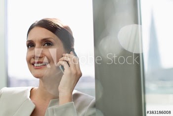 Smiling corporate businesswoman talking on smart phone
