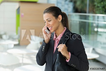 Smiling corporate businesswoman talking on smart phone