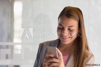 Smiling corporate businesswoman using smart phone