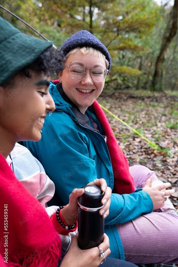 Smiling female friends camping in forest
