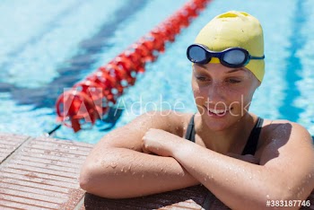 Smiling female swimmer in sunny swimming pool