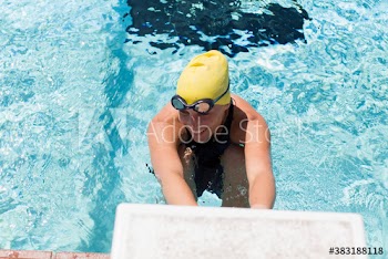 Smiling female swimmer practicing in sunny swimming pool
