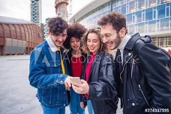 Smiling friends using smartphone on street