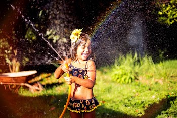 Smiling Girl Playing With Water Hose