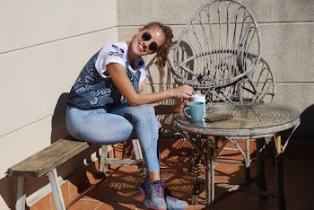 Smiling Girl Sitting On Bench Stirring Coffee