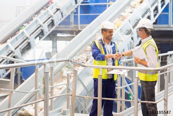 Smiling male workers shaking hands in factory