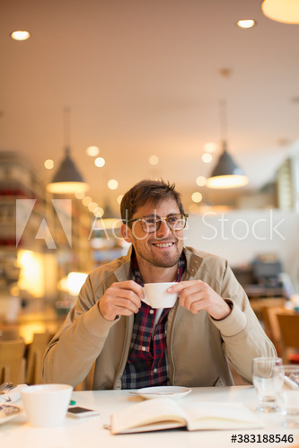 Smiling man drinking coffee in cafe