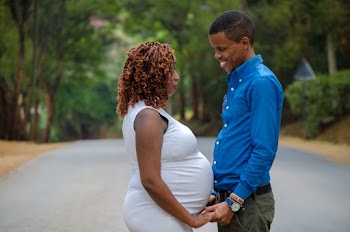 Smiling Man Facing and Holding Hands of Pregnant Woman