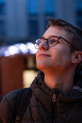 Smiling Man in Black Bubble Jacket Wearing Eyeglasses