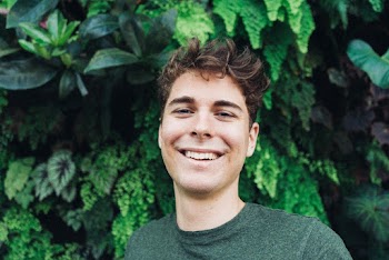 Smiling Man in Front of Green Plants
