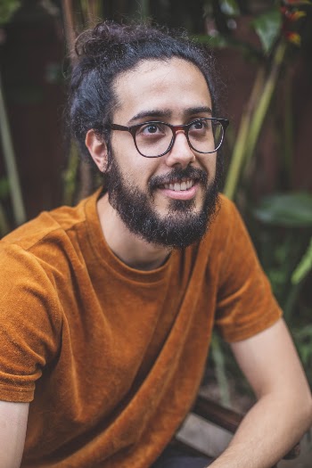 Smiling Man in Orange Crew Neck T-shirt and Black Framed Eyeglasses