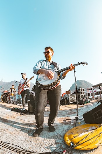 Smiling Man Playing Banjo Near Another Man Playing Guitar