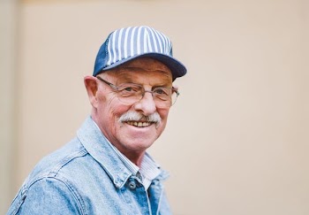 smiling man wearing blue denim collared top