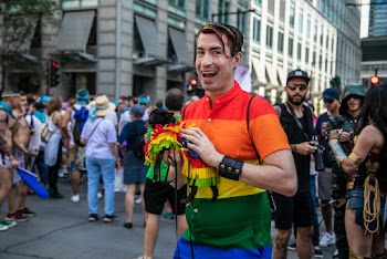 Smiling Man Wearing Multicolored Striped Shirt Standing Beside People Holding Cameras