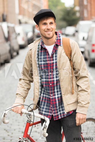 Smiling man with bicycle on city street