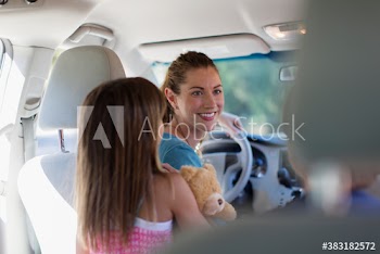 Smiling mother and children inside car