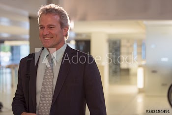 Smiling senior businessman in office lobby