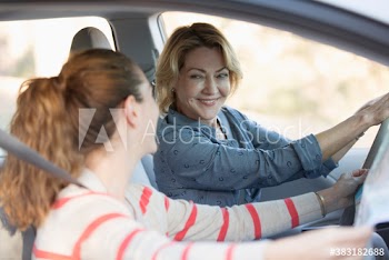 Smiling senior mother and daughter enjoying road trip in car