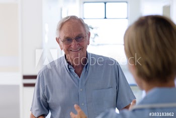 Smiling senior patient talking with nurse in clinic