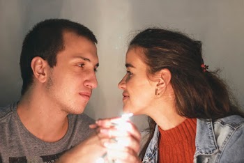 Smiling Woman Facing Man and Both Are Holding There Hands