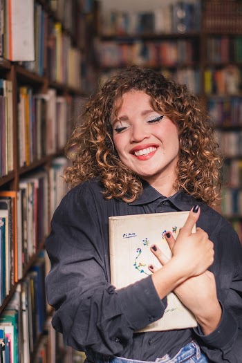 Smiling Woman Holding a book  in Library