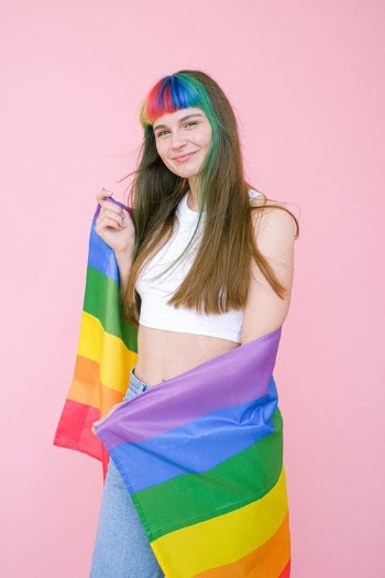 Smiling Woman Holding a Gay Pride Flag · Free Stock Photo