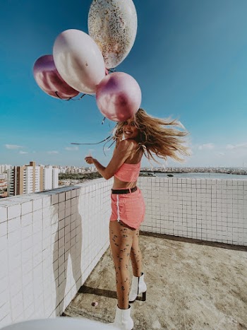 Smiling Woman Holding Balloons