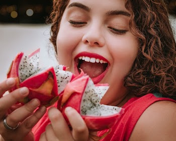 Smiling Woman Holding Dragon Fruits