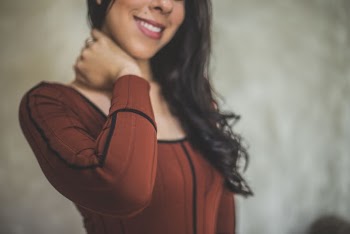 Smiling Woman Holding Neck Using Right Hand
